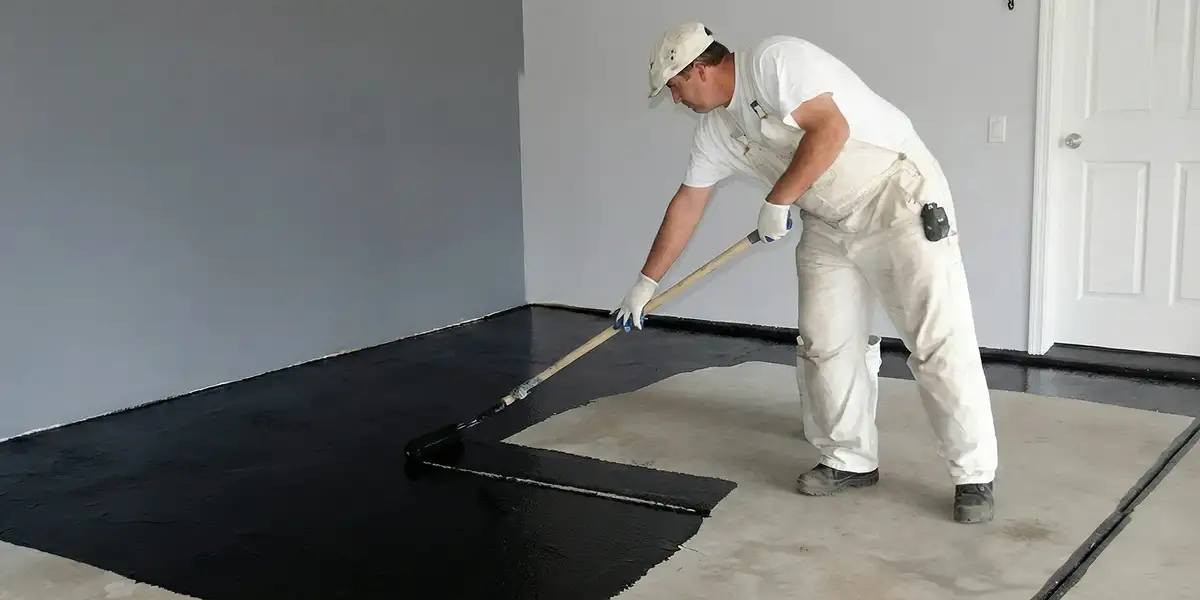 basement waterproofing professional applying waterproof coating to protect a basement floor in Erie, PA